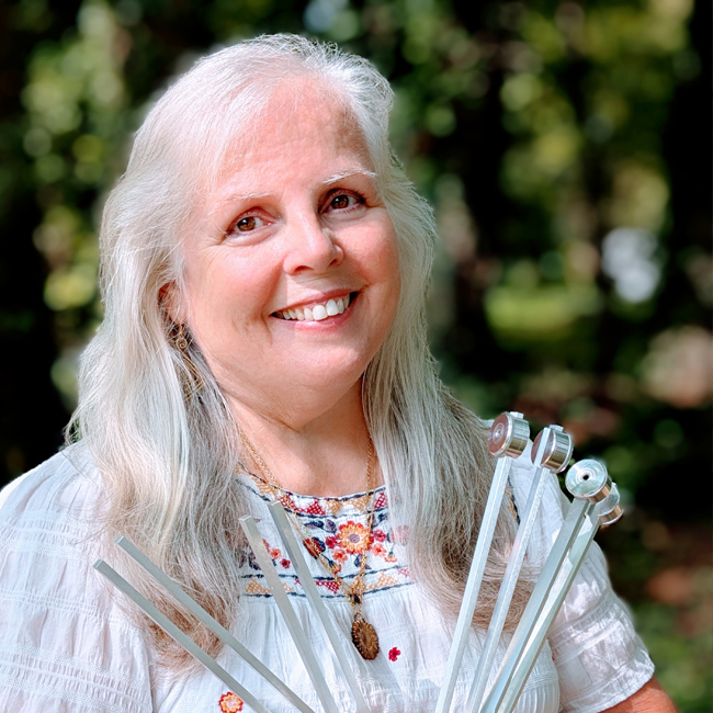 A photograph of Brava holding her tuning forks.
